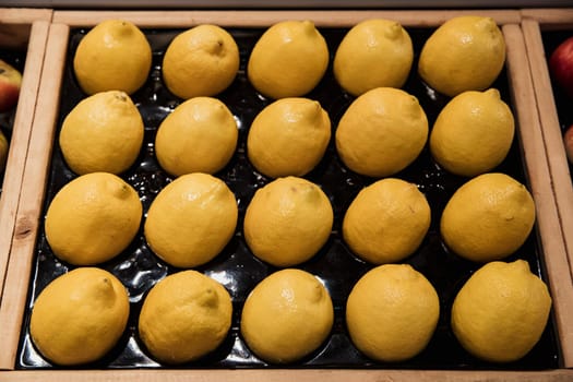A close-up shot of an abundance of fresh Lemons on display at a market stall.
