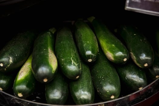 A close-up shot of an abundance of fresh courgette's on display at a market stall.