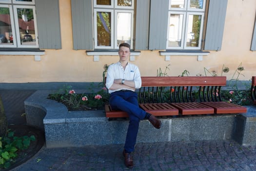 Young man sitting on bench in outdoors