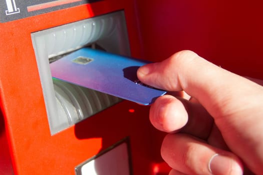Hand of a man with a credit card, using an ATM. Man using an atm machine with his credit card.