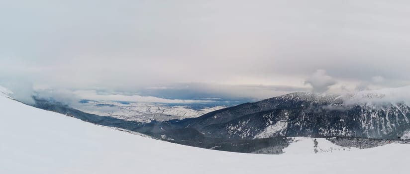 Beautiful view from the top of Pirin mountains, snowy winter morning above the clouds, Bankso, Bulgaria.