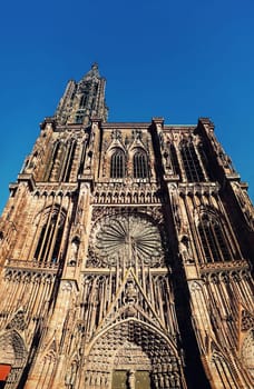 Main entrance of Roman Catholic Cathedral Notre Dame of Strasbourg in Alsace, France. Beautiful sunny day with clear blue sky. Majestic gothic architecture.