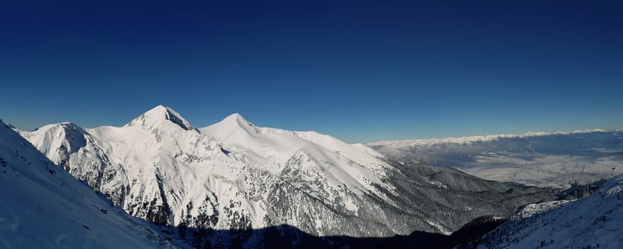 Pirin mountains winter snow peaks panorama with clear blue sky in Bansko, Bulgaria.