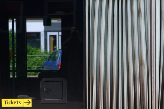 The close-up of the chassis of a articulated bus with a bellows as well as windows...
