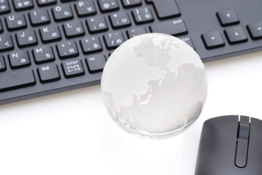 Glass globe ball with keyboard on white background