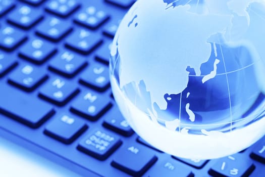 Glass globe ball with keyboard on white background