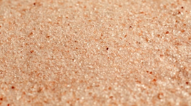 Background texture of fine ground red Pakistani hill salt colored naturally with iron oxide in a full frame panorama banner
