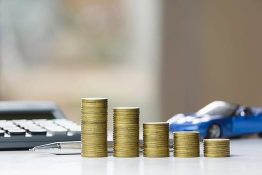 Car insurance and car service. Line graph with stack of coins and toy car, business and financial concept.