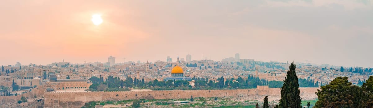Panoramic view of Jerusalem old city and the Temple Mount during a dramatic colorful sunset. A view of the Dome of the Rock and Al Aqsa Mosque from the Mount of Olives in Jerusalem, Israel.