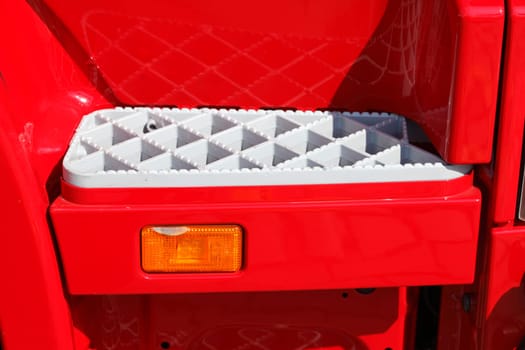White metal steps on a red truck..