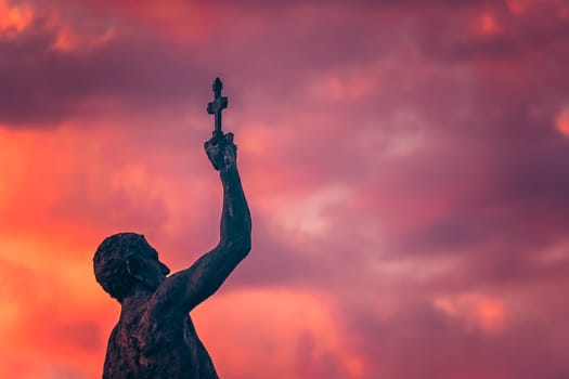Catcher of a Cross statue in Ohrid town during dramatic sunset, Northern Macedonia