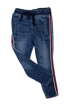 Fashionable denim clothes. Trendy stretch blue jeans trousers with lateral red stripes isolated on a white background. Fashionable jeans for child boy.