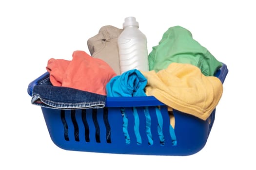 Wash basket isolated. Closeup of colorful dirty clothes and a white detergent bottle in a blue laundry basket isolated on a white background.