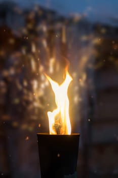 Fire burning inside metal torch in front of a wooden shed in a Sami people village, northern Norway