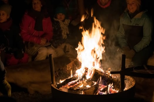 Tromso, Norway -  December 2018 : Tourists gathering by the fire inside a large Sami tent to listen to traditional folk stories in winter, Tromso region