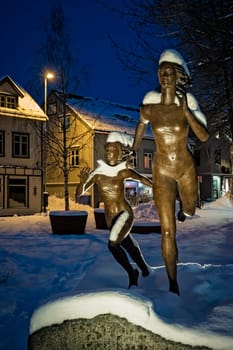 Tromso, Norway -  December 2018 : Running women statue in Skippergata part of Tromsø town at night