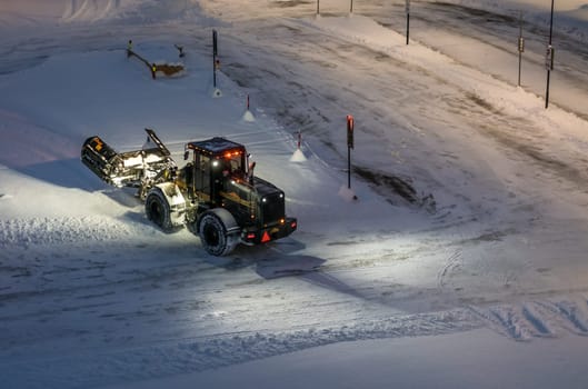Tromso, Norway -  December 2018 : Powerful snowplough clearing parking lot in Tromso town in winter