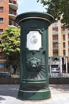 green iron drinking water fountain with lion head in downtown bilbao spain