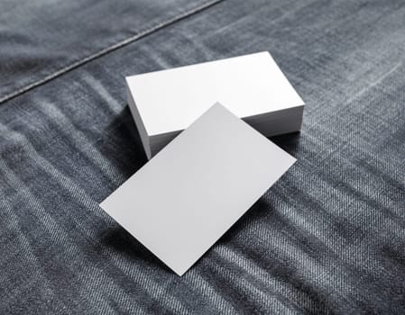 Blank name cards on gray denim background. Mockup of business cards. Selective focus.