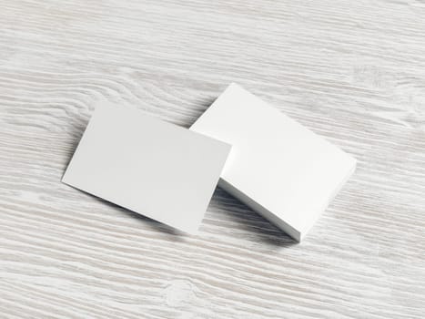 Photo of blank white business cards on light wood table background. Copy space for text.