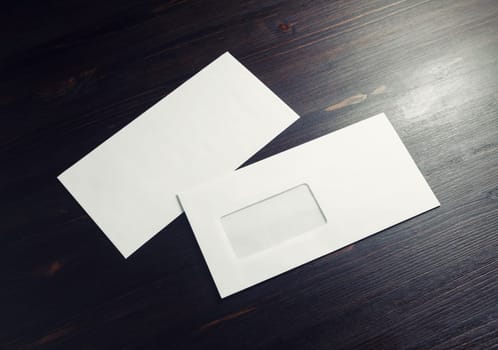 Blank envelopes with window on dark wooden background. Front and back side. Copy space for text.