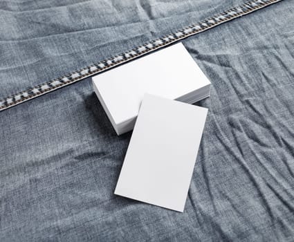 Blank white name cards on denim background. ID mock up.