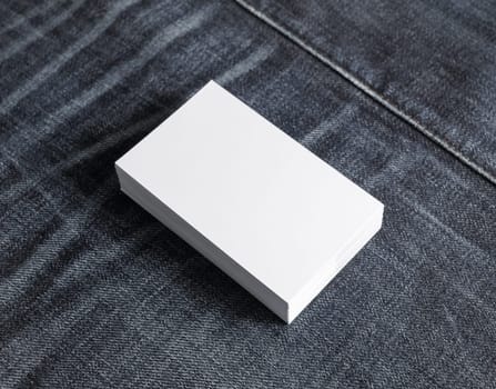 Photo of blank business cards stack on denim background.. Template for branding identity.