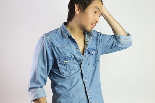 Portrait Man in Jeans Shirt or Denim Shirt Fashion Swing Hair Up Pose. Jeans shirt or denim shirt fashion for men on grey background