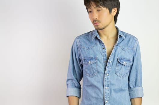 Portrait Man in Jeans Shirt or Denim Shirt Fashion Looking Below. Jeans shirt or denim shirt fashion for men on grey background