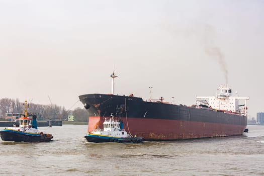 Big Cargo Containers Boat with Goods cargo Stack at the Pier docks port waiting for international sea freight transportation in Rotterdam Port of Netherlands