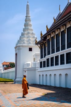 Bangkok, Thailand, March 2013 Single Thai monk praying in front of Grand Palace back balcony