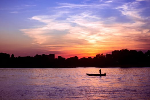 Beautiful landscape with colorful sunset on cloudy sky on Danube river in Serbia.