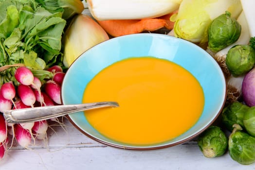plate of pumpkin soup with  several vegetables