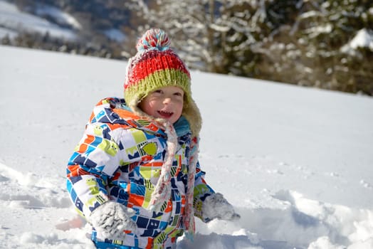 little 3 year old child playing in the snow