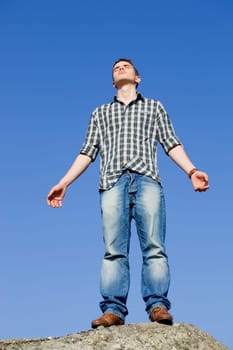 young casual man with the sky as background