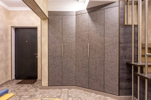 The interior is a spacious hallway, with large closets and a staircase to the second floor