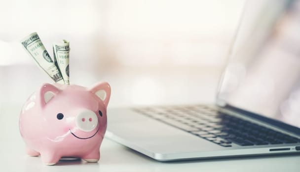 piggy bank with laptop on the desk, online shopping concept