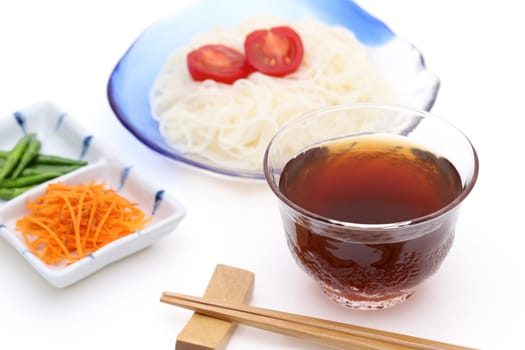 Japanese somen noodles in a glass plate with Mentuyu on white background