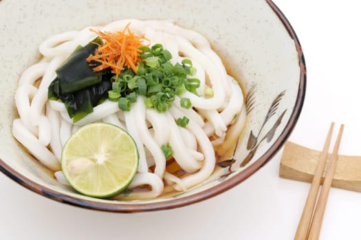 Japanese bukkake udon noodles in a ceramic bowl on white background