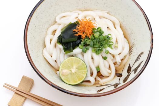 Japanese bukkake udon noodles in a ceramic bowl on white background