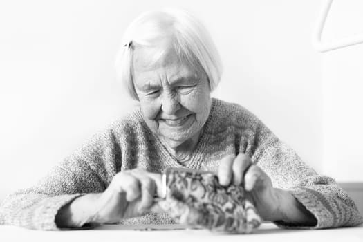 Detailed closeup photo of elderly 96 years old womans hands counting remaining coins from pension in her wallet after paying bills. Unsustainability of social transfers and pension system.
