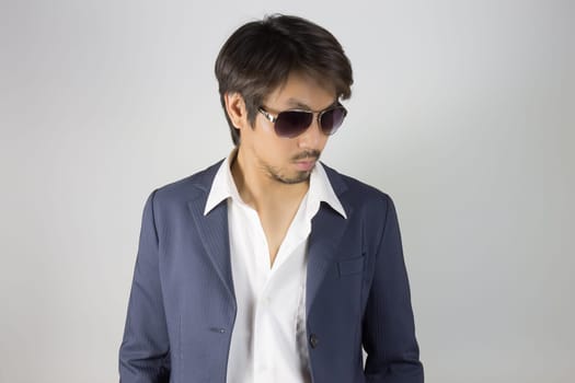 Portrait Man in Navy Blue Suit Wear Black Eyeglass or Eyewear. Portrait man in navy blue suit and white shirt on grey background in smart style