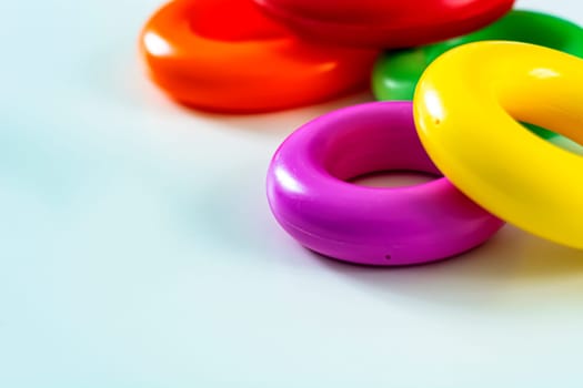 Colorful plastic rings on a white background to be stacked in a tower. Toy for newborns.