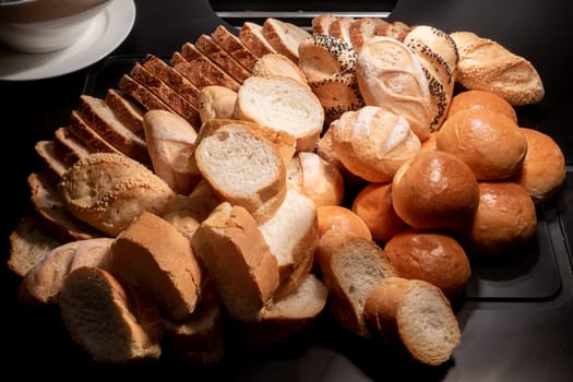variety of bakery bread and rolls station in buffet line