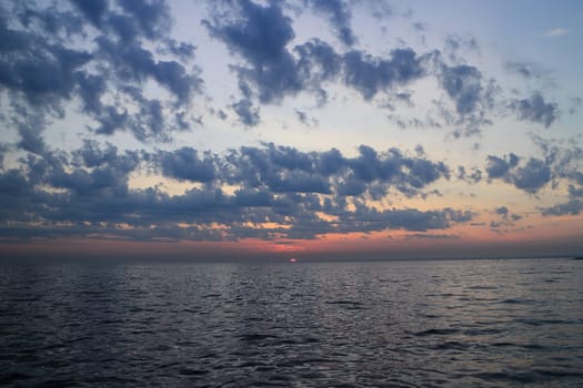 purple sunset dramatic seascape, sun drowned in the sea, panorama