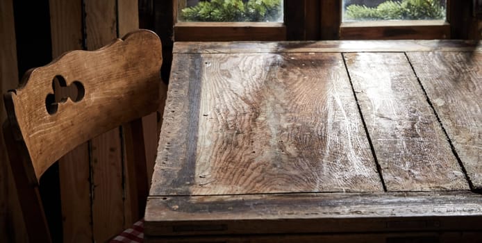 Empty old wooden table and cottage style chair in front of a window ready for product or food placement