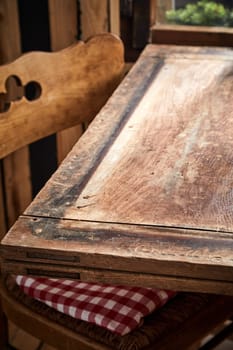 Empty old wooden table with vintage chair in a close up low angle view for food or product placement