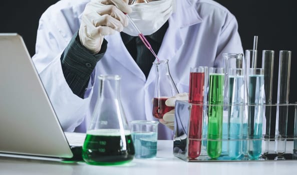 Researcher with glass laboratory chemical test tubes with liquid for analytical , medical, pharmaceutical and scientific research concept.