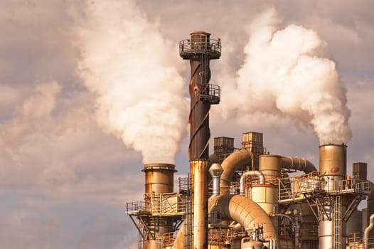 Industrial plant with smoking smokestack,tube,silos.