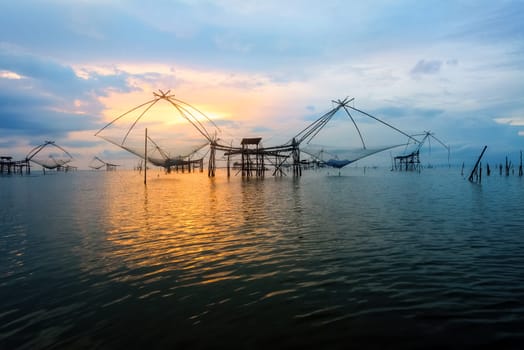 Beautiful nature landscape golden light of the morning sky at sunrise and native fishing tool rural lifestyle at Pakpra canal, Songkhla Lake, Baan Pak Pra is a famous landmark of Phatthalung, Thailand